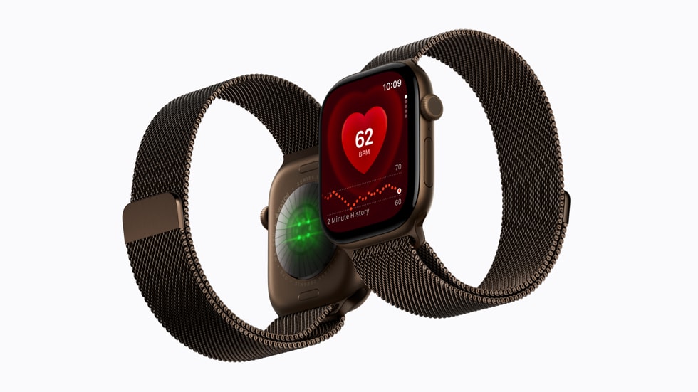 图中并排摆放着两只 Apple Watch Series 12 设备，其中一只展示着表背上的传感器，另一只在表盘上展示着心率 app。