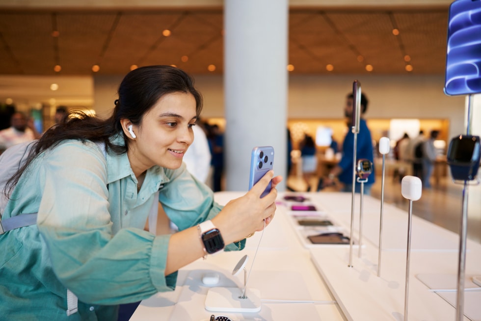 一位顾客在 Apple BKC 零售店内试用 AirPods 5 和 iPhone 18 Pro。
