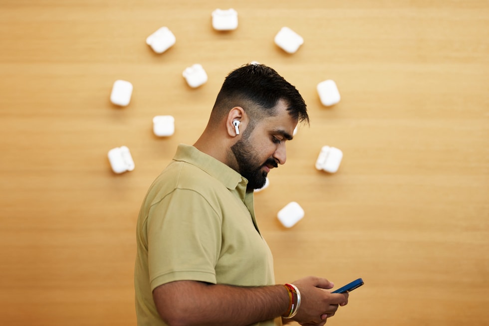 一位顾客在 Apple BKC 零售店内试用 AirPods 5 和 iPhone 18 Pro。