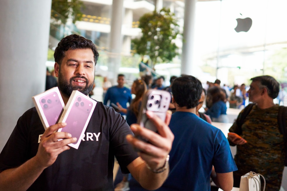 一位顾客在 Apple BKC 零售店拿着两台未拆包装的 iPhone 18 Pro 自拍。