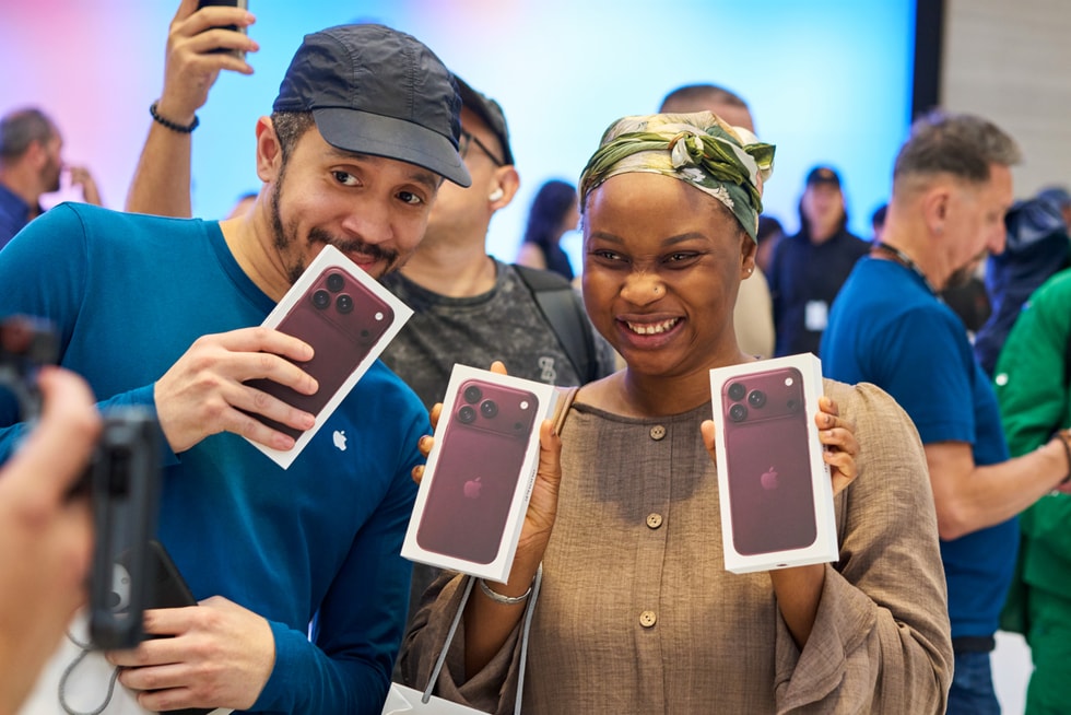 一位顾客和一位 Apple 团队成员在 Apple 第五大道零售店手持刚刚购买的 iPhone 18 Pro。