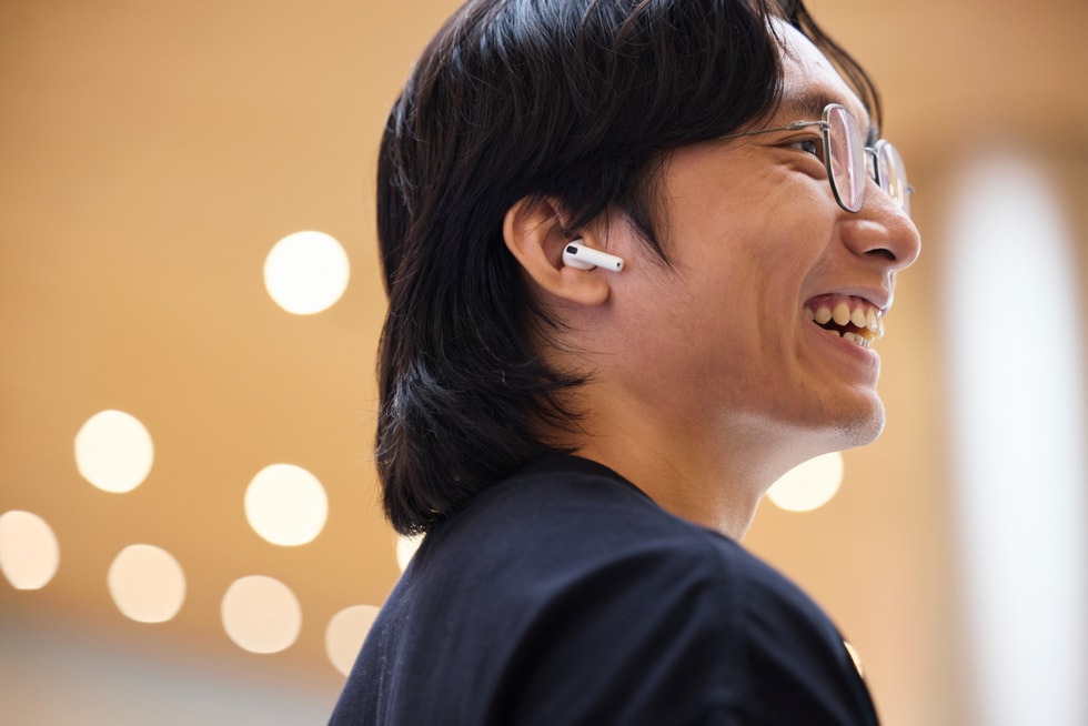 一位顾客在 Apple 静安零售店试戴 AirPods 5。