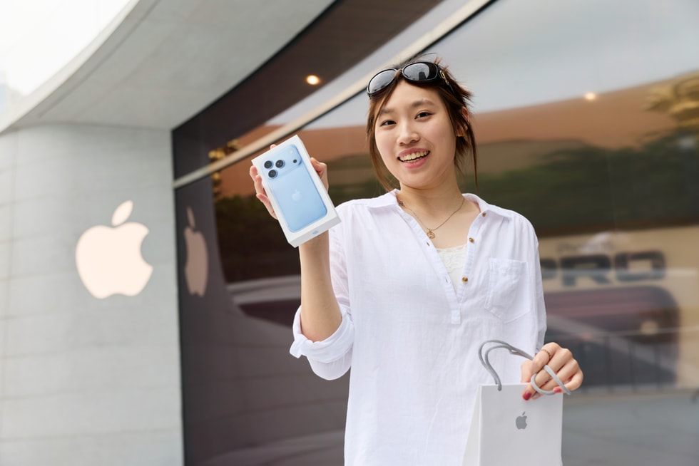 一位顾客在 Apple 静安零售店外手持刚刚购买的新款 iPhone 18 Pro。