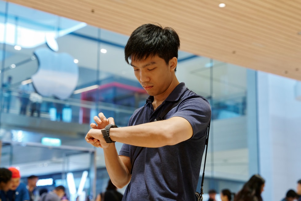 一位顾客在 Apple The Exchange TRX 零售店内查看手腕上的 Apple Watch Ultra 4。