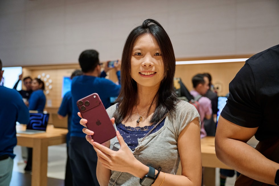 一位顾客在 Apple The Exchange TRX 零售店内举起 iPhone 18 Pro。