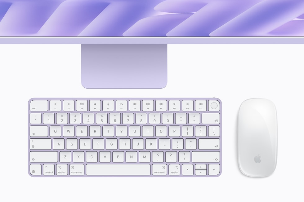 搭载 M6 芯片的紫色 iMac 下方放有同色系键盘、鼠标和触控板。