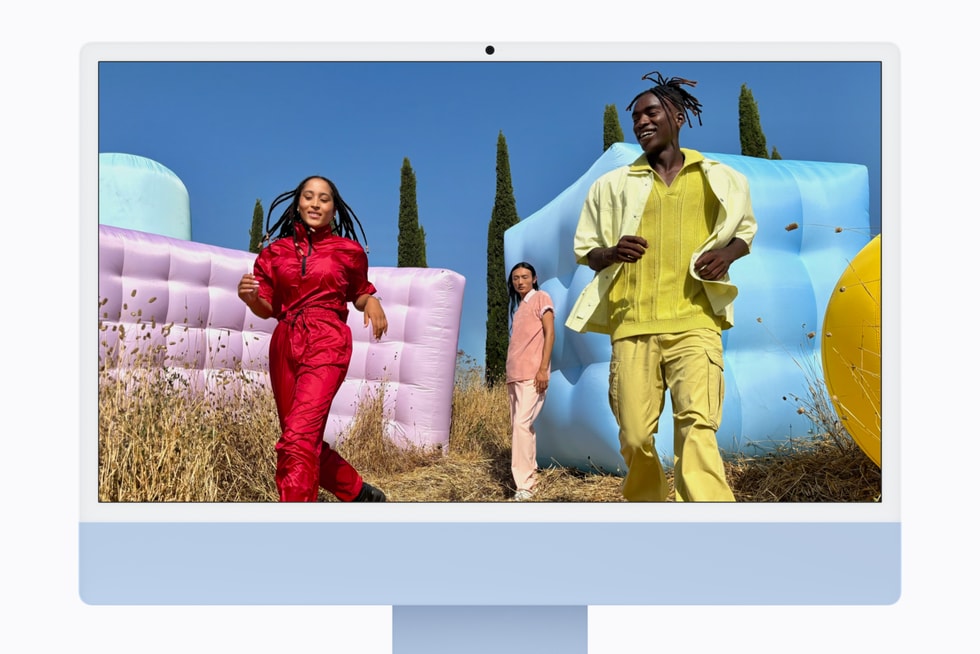 搭载 M6 芯片的蓝色 iMac 上显示着三个人在户外的静态画面。