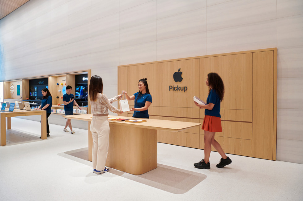 一名 Apple 团队成员在 Apple Brompton Road 零售店内的 Apple Pickup 区域把一袋产品交给顾客。