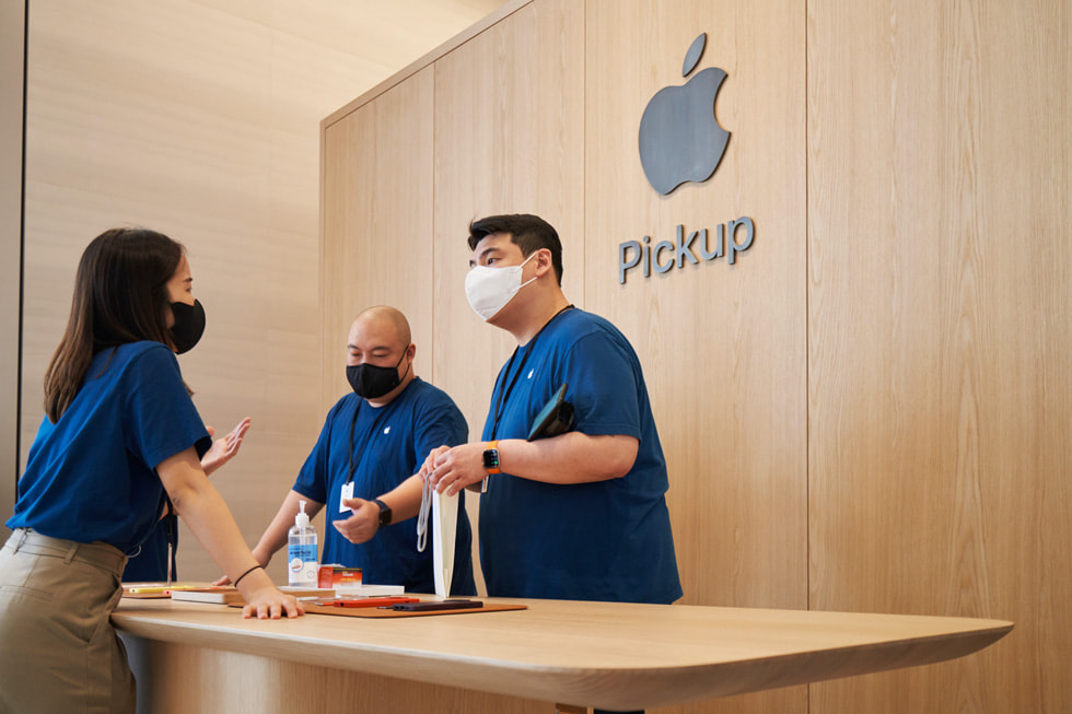在 Apple 明洞零售店内专属的 Apple Pickup 取货区域，团队成员正在交谈。