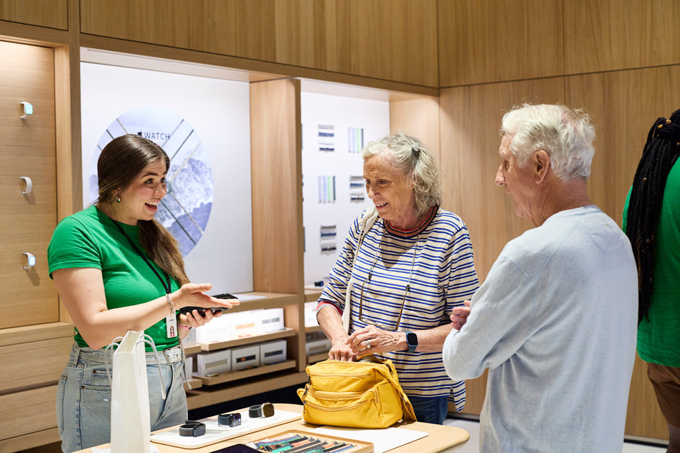 一名团队成员在 Apple Watch 展示区为顾客提供协助。