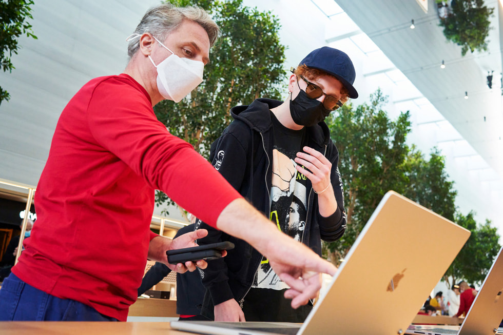 Apple The Grove 团队成员向顾客展示新款 MacBook Pro。