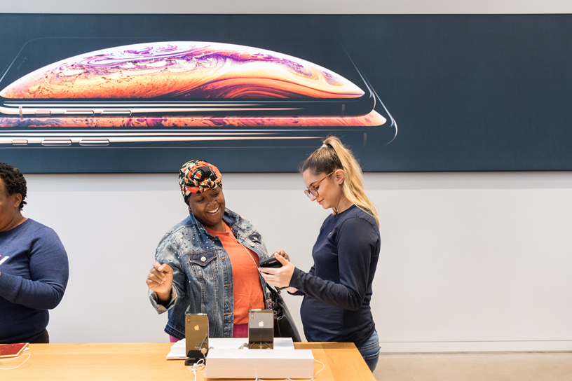 Apple Fifth Avenue 店内的一位顾客和苹果员工。
