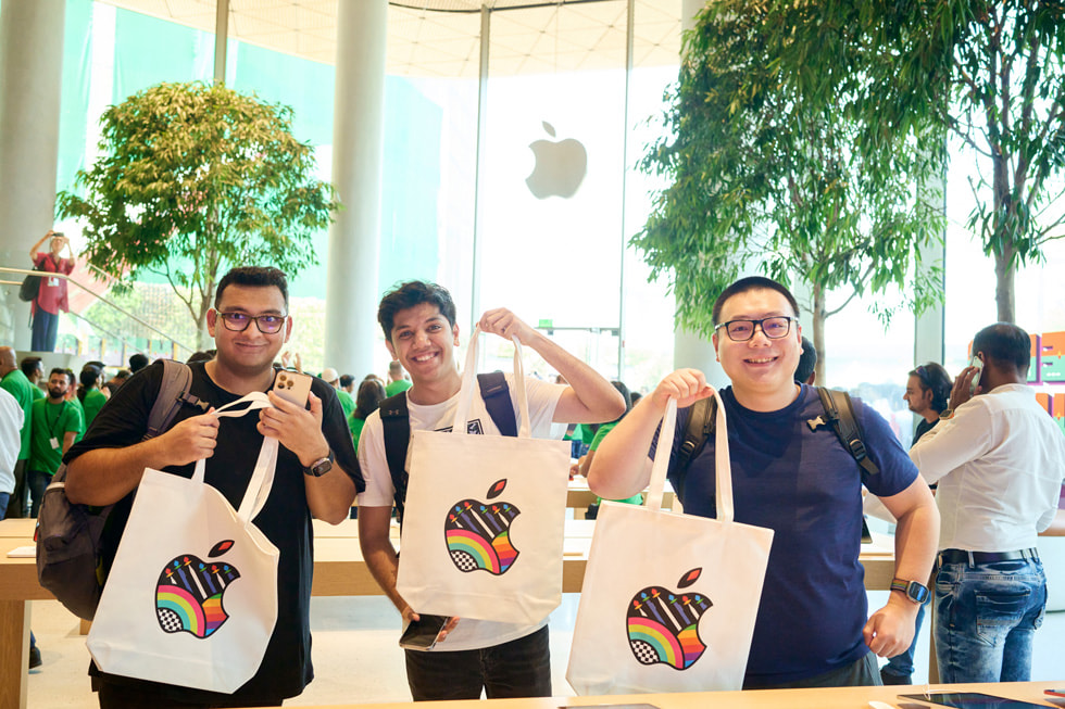 顾客背着印有 Apple logo 的托特包拍照。 