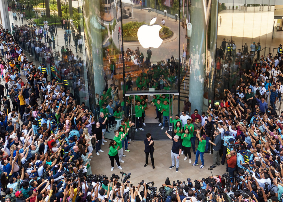 Tim Cook、Deirdre O’Brien 与团队成员鼓掌欢迎首批顾客光临 Apple BKC 零售店。