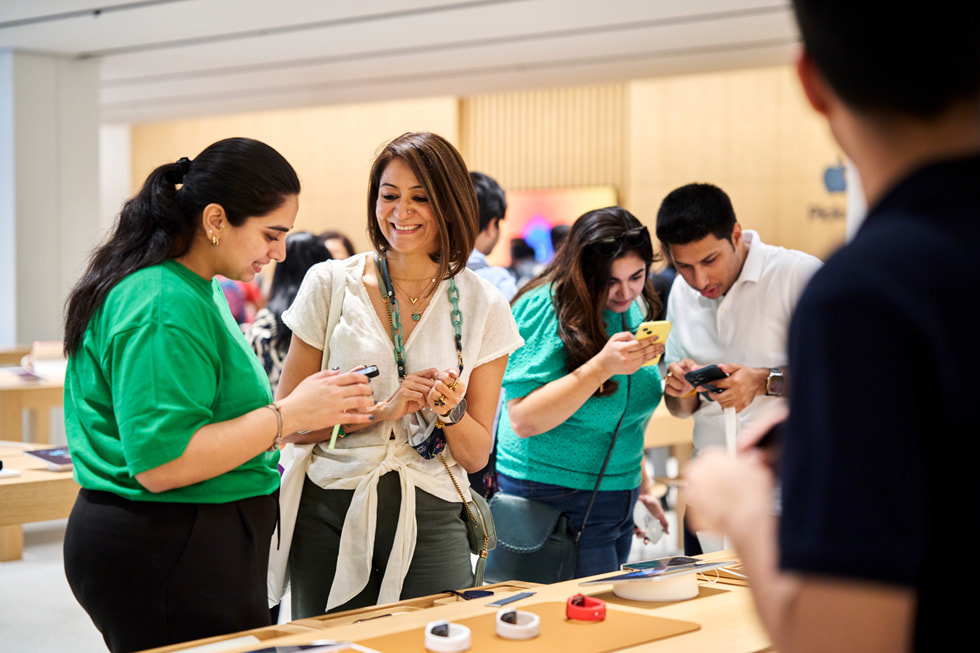 一名团队成员在展示桌前协助顾客探索最新 Apple Watch 系列产品。