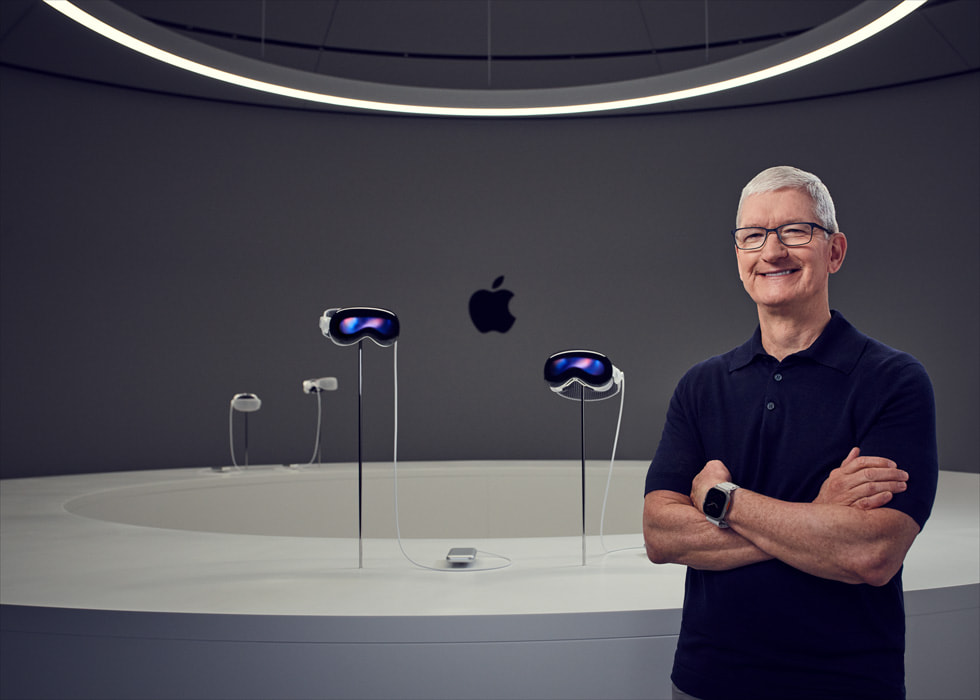 Apple CEO Tim Cook 站在 Apple Vision Pro 的展示桌旁。