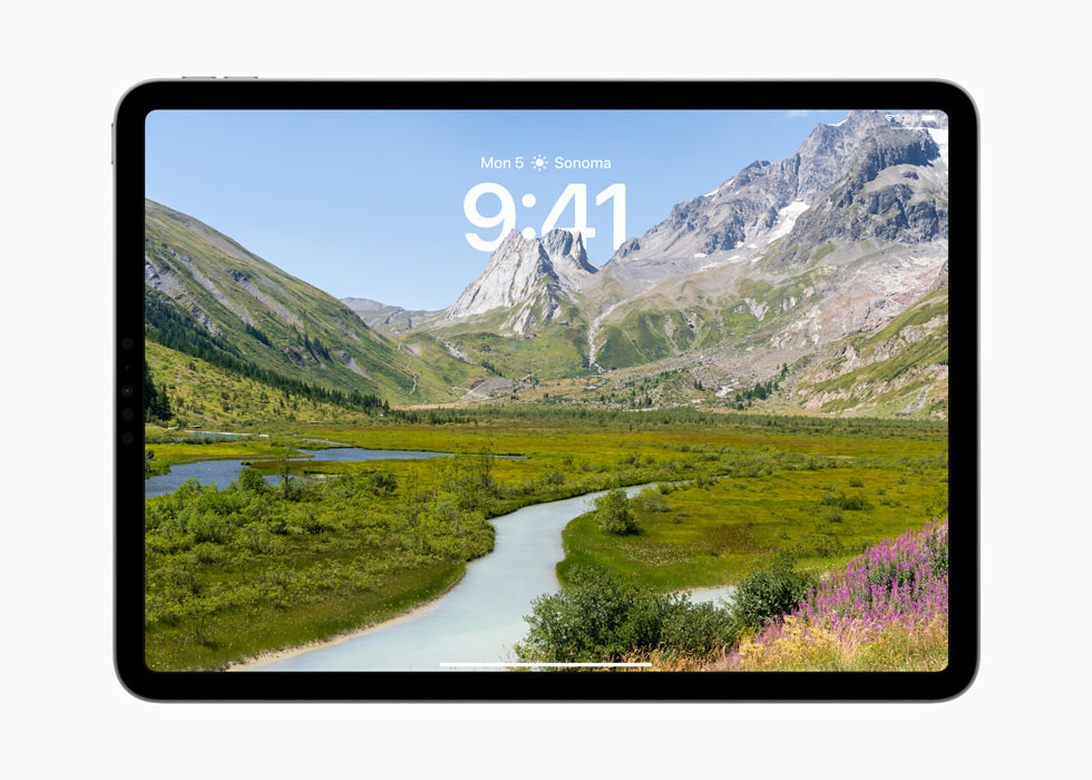 iPad Pro 的锁定屏幕上显示着高山的照片，山峰位于时间之前。