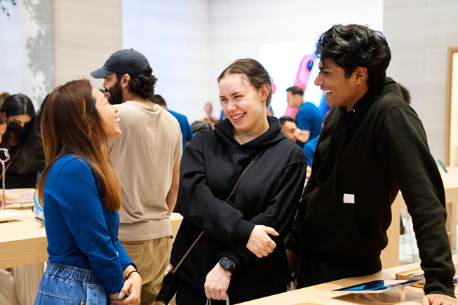 Apple 团队成员与顾客在 Apple Store 零售店交流。