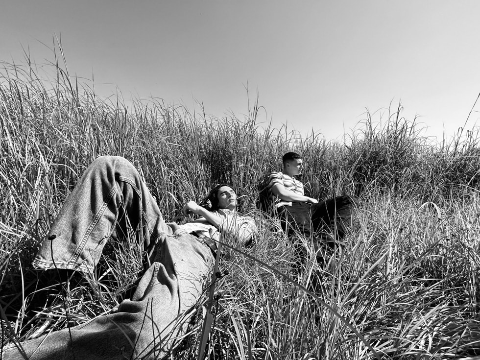 两个人倚靠在田野里的黑白照片。