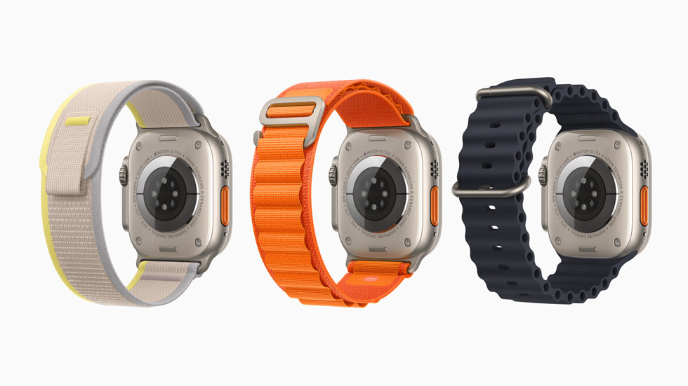 3 支 Apple Watch Ultra 设备的背面展示图，显示 3 款不同表带，包括灰黄相间的野径回环式表带、橙色的高山回环式表带和黑色的海洋表带。 