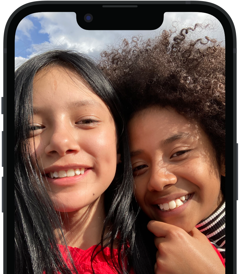 旁白”功能以英语描述 iPhone 上“两人微笑着摆姿势拍照片”的画面，并显示语音输出内容。'