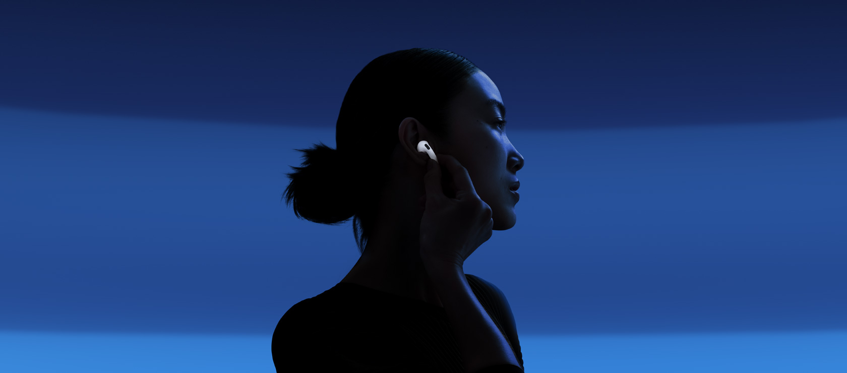 一个人通过触碰 AirPods 5 耳机柄启用主动降噪功能