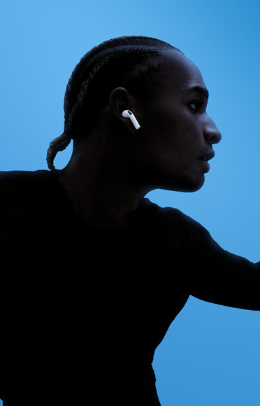 一个人戴着 AirPods 5，手臂伸展，背景是彩色画面