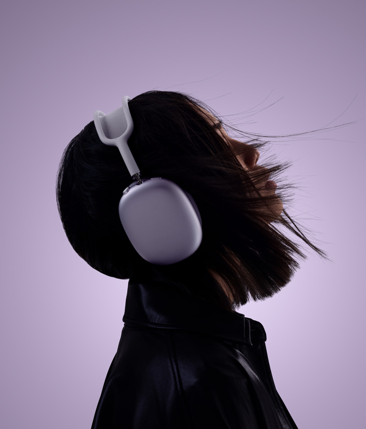 戴着紫色 AirPods Max 2 耳机的人物侧影，其头部微微向上扬起。