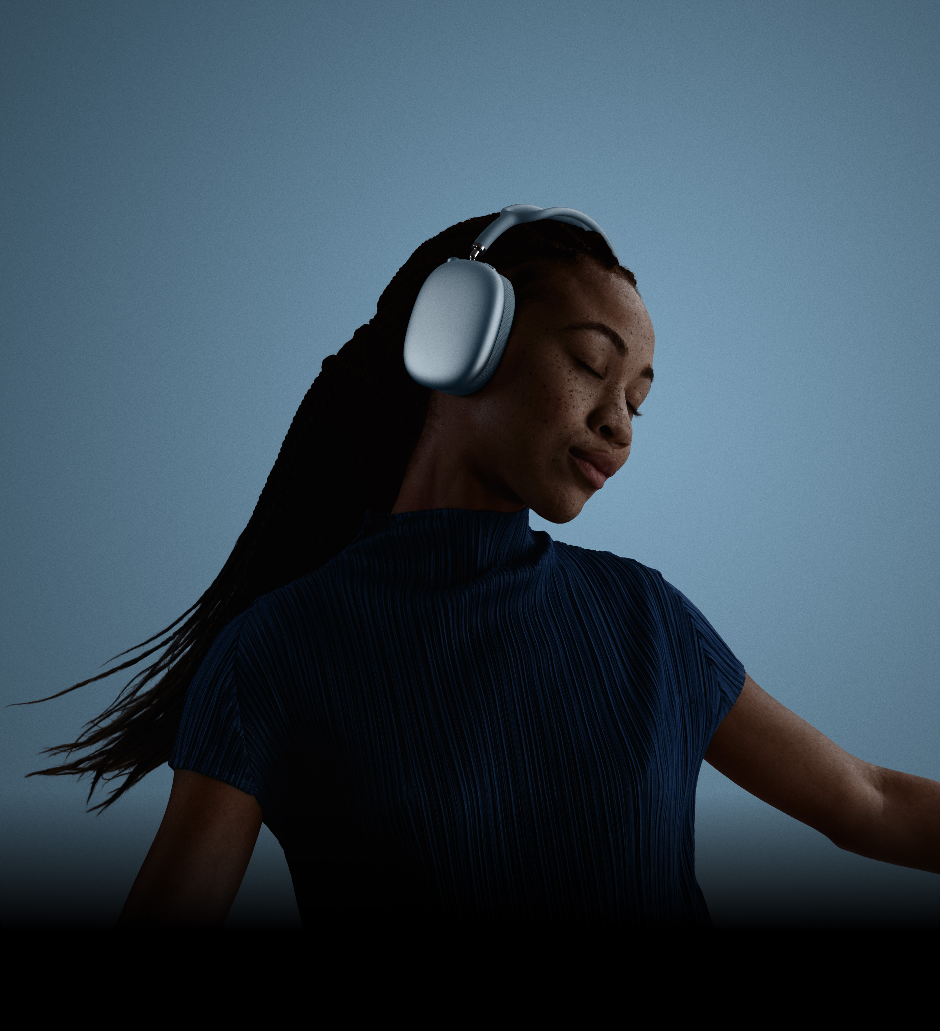 戴着蓝色 AirPods Max 2 耳机的人物侧影，画面中的人闭着眼睛，头向一侧倾斜。