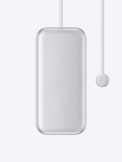 Apple Vision Pro 电池的外观，展示位于中央的 Apple 标志、自带的电源线，以及线缆末端配备 LED 指示灯的圆形接头。
