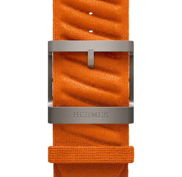 Orange 橙色 Apple Watch Hermès Ultra 3 En Mer 表带，展示原色五金件和表扣上镌刻的 Hermès 标志