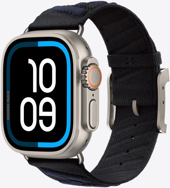 Apple Watch Hermès Ultra 3，展示原色钛金属表壳、全面屏和圆角设计、右侧外观、数码表冠、麦克风、凸起的侧边按钮、“航海”数字表盘 (时间数字为 10、09)，以及搭配的 Noir/Bleu Nuit 黑配午夜蓝色 En Mer 表带 (黑色配深蓝色斜条纹)，表带采用针织聚酰胺纱线材质，中央具有调节孔，配有原色钛金属表扣和五金件。