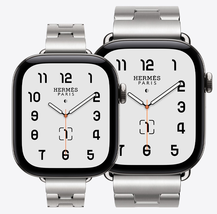 Apple Watch Hermès Series 12,展示 42 毫米和 46 毫米银色钛金属表壳款式,42 毫米表壳搭配 Satiné 缎灰色 Grand H Fin 表带,46 毫米表壳搭配 Satiné 缎灰色 Grand H 表带,展示经典模拟表盘 (时针、分针和秒针,以及月相、日期复杂功能)。