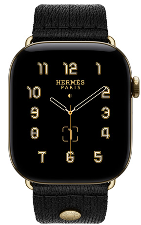 Apple Watch Hermès Series 12,展示 Clou de Selle 模拟表盘 (时针、分针和秒针,以及月相、日期复杂功能)、炫金色钛金属表壳、右侧外观、数码表冠、侧边按钮,搭配 Noir 黑色 Satin Clou de Selle 表带,展示顺滑的黑色缎面织带,以及与表壳适配的炫金色五金件。