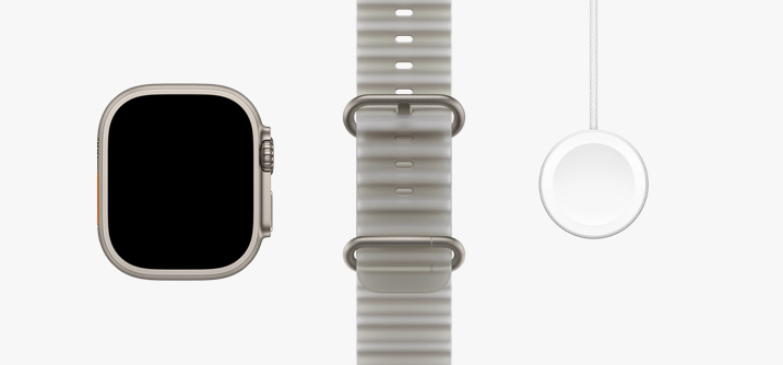 Apple Watch Ultra 4，展示原色钛金属表壳、全面屏设计、半透明灰色海洋表带、Apple Watch 磁力充电器转 USB-C 连接线。