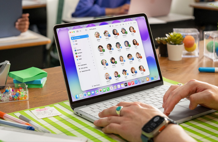一位教师坐在打开的 Mac 前，屏幕上的课堂 app 显示出一份完整的学生名单。
