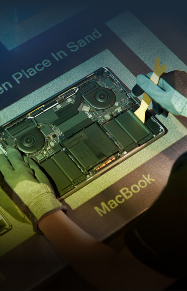 戴着手套的双手正在拆解 MacBook，内部组件清晰可见。