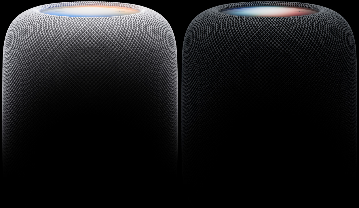 白色和午夜色两部 HomePod 扬声器并排摆放，展示声学网面织物和发光的触控面板。