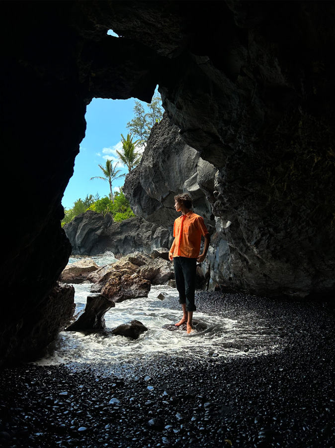 主摄像头拍摄的照片，一名女子站在岩洞口向外张望。