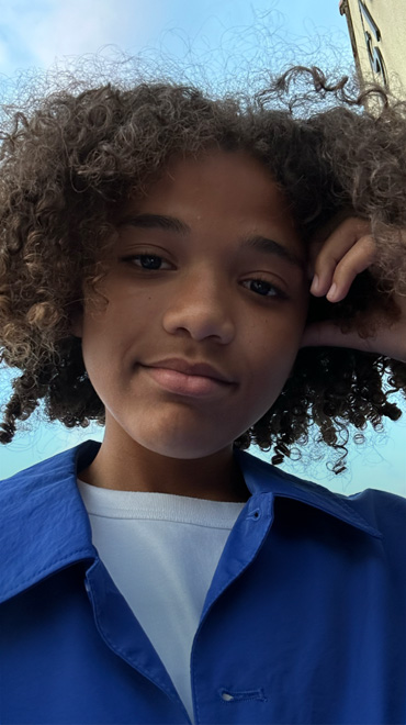 以原深感摄像头拍摄的低光自拍照，画中一人身穿蓝衣看向镜头