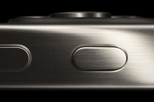 iPhone 15 Pro 的侧面特写，展示钛金属边框、操作按钮和音量增大按钮