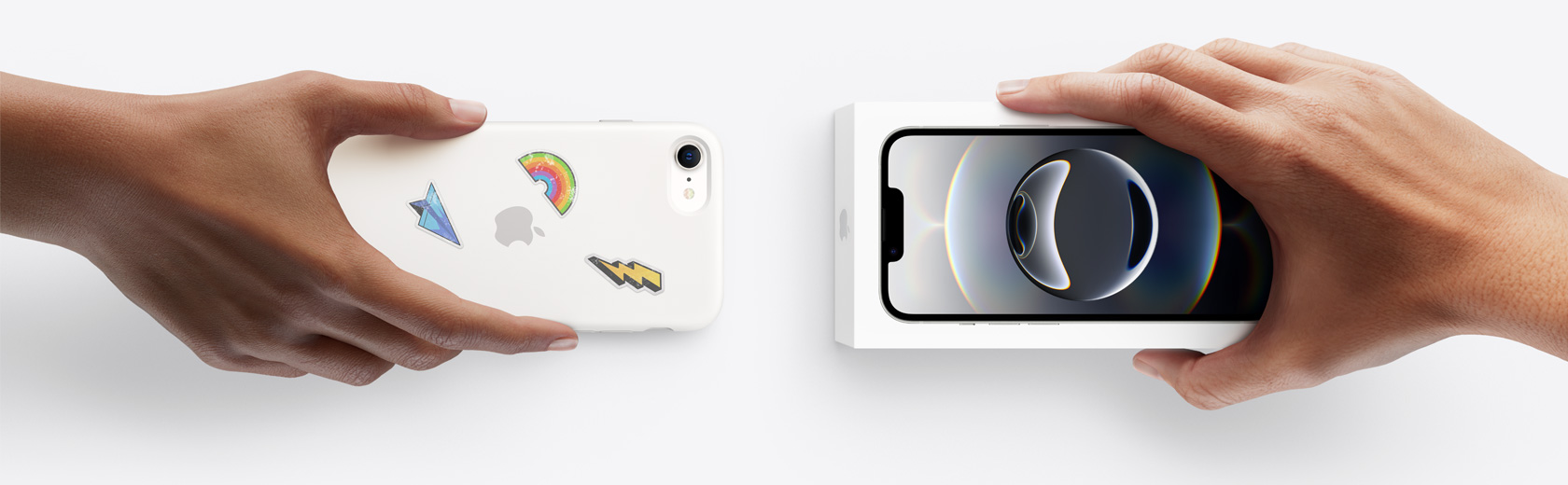 一只手拿着一部用于换购的 iPhone，换取另一只手中未拆封的 iPhone 16e。