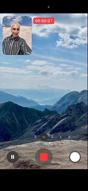 一个人演示视频同步双拍功能，使用前置摄像头拍摄自己，同时用后置摄像头拍摄风景如画的远山。