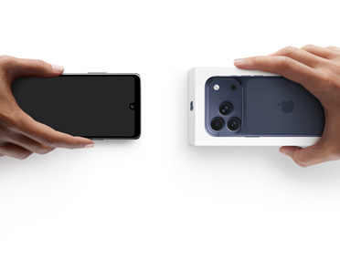 左边一只手拿着一部用于折抵的其他智能手机，换取右边另一只手中未拆包装的全新 iPhone 17 Pro。