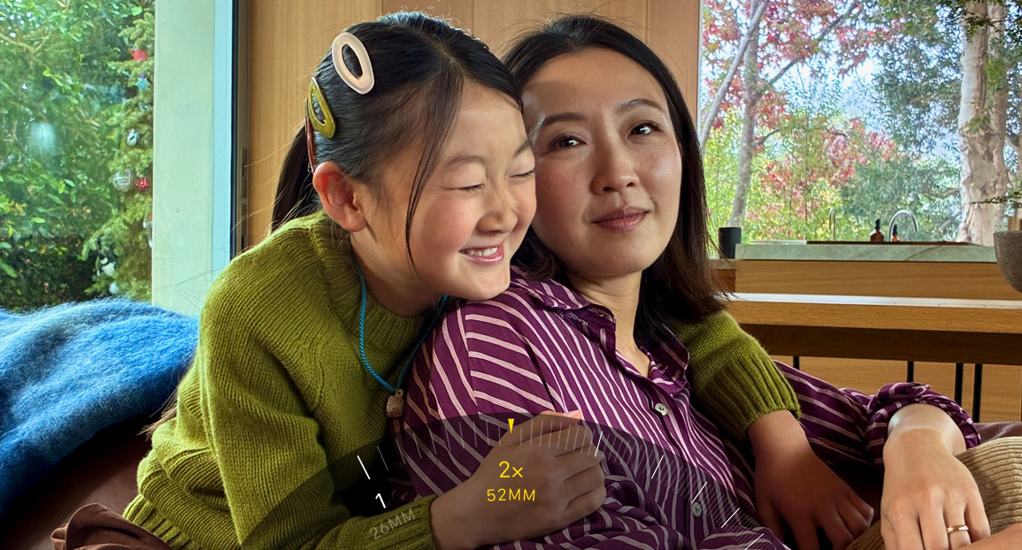 展示正在使用 2 倍长焦功能，放大拍摄相拥的两个人。