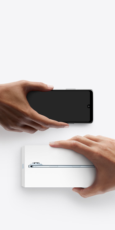 左边一只手拿着一部用于折抵的其他智能手机，换取右边另一只手中未拆包装的全新 iPhone Air。