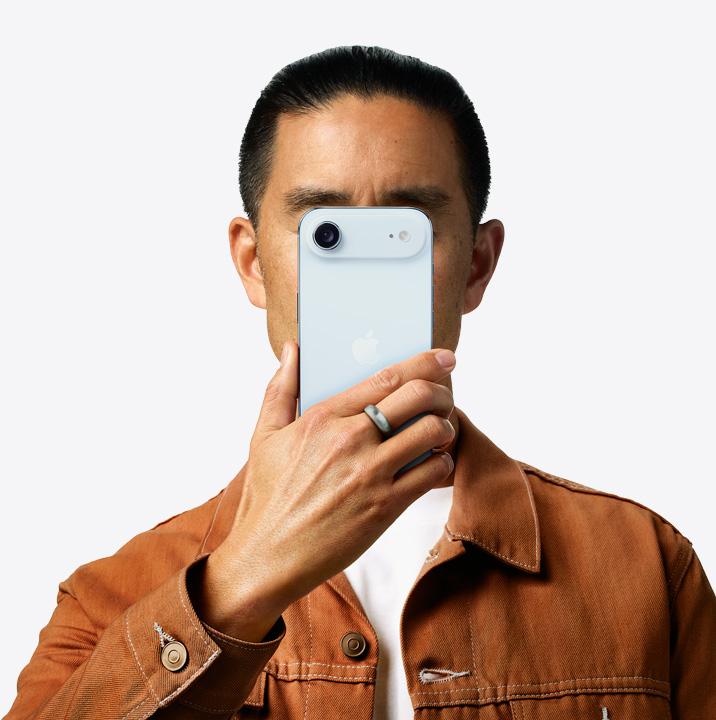 一个人手拿天蓝色 iPhone Air 举在面前，展示机身背面，左上角是摄像头系统。