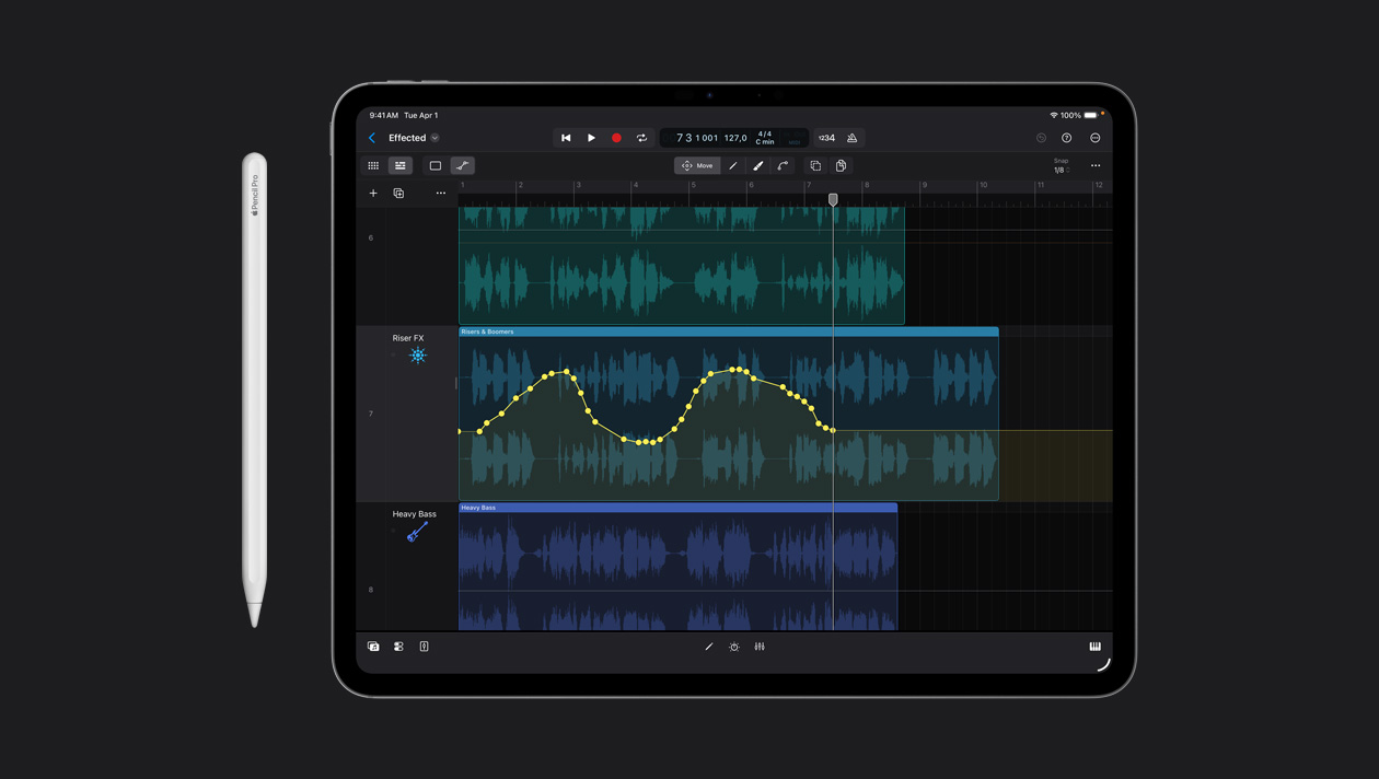 13 英寸 iPad Pro 屏幕工作区，展示在 Logic Pro 中的声波上绘制图形，设备左侧放着一支 Apple Pencil。