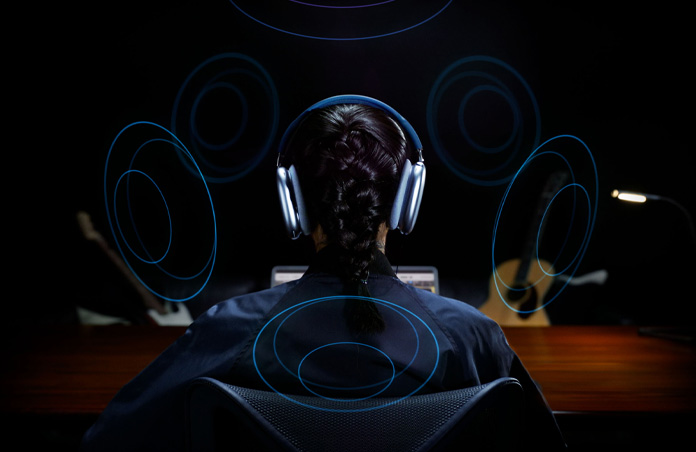 一个人头戴 Apple AirPods Max 的背部图，头部周围环绕着多个图形，表示空间音频。