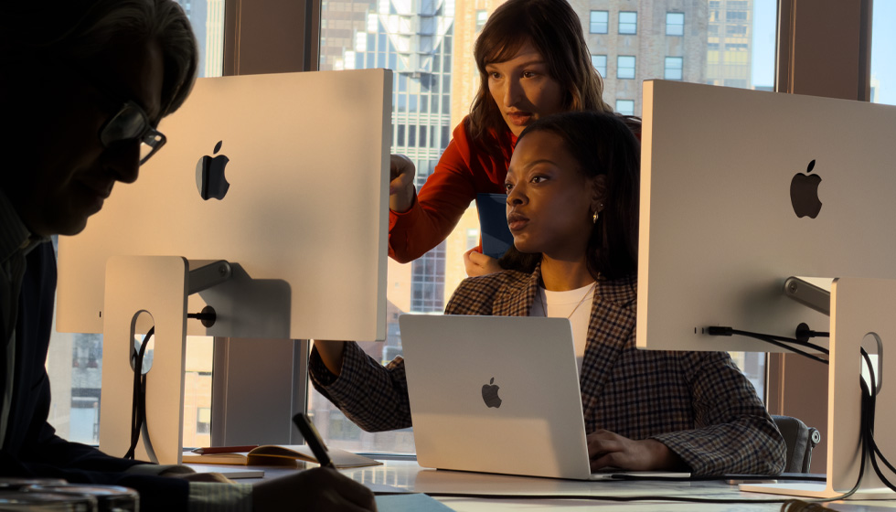 工作场景中，人们正在使用 Mac。